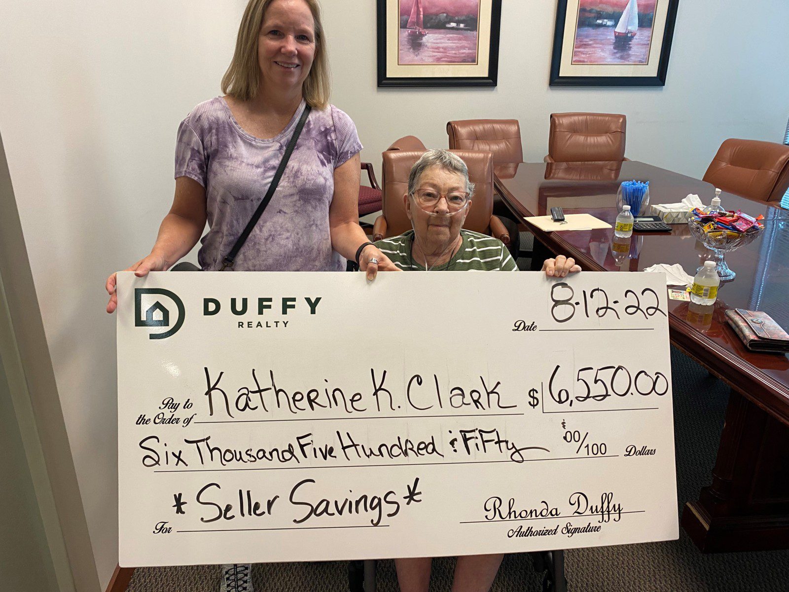 DUFFY sellers holding a $6,550 seller-savings check